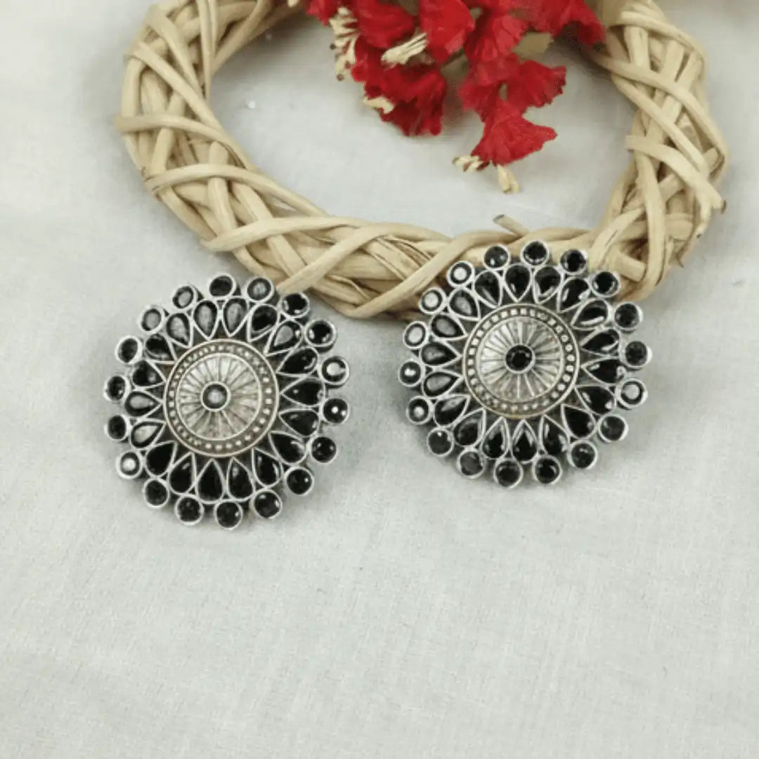 Close-up of the intricate ethnic carvings around a round black onyx stone in vintage silver stud earrings