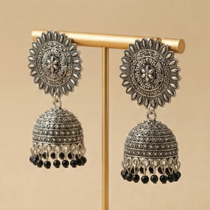 Side profile of traditional Pakistani silver jhumkas showing the dome shape and craftsmanship.