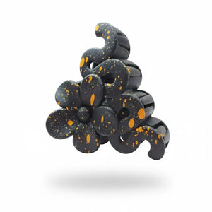 Close-up of sculptural black hair clip showing gold details and interlocking teeth.