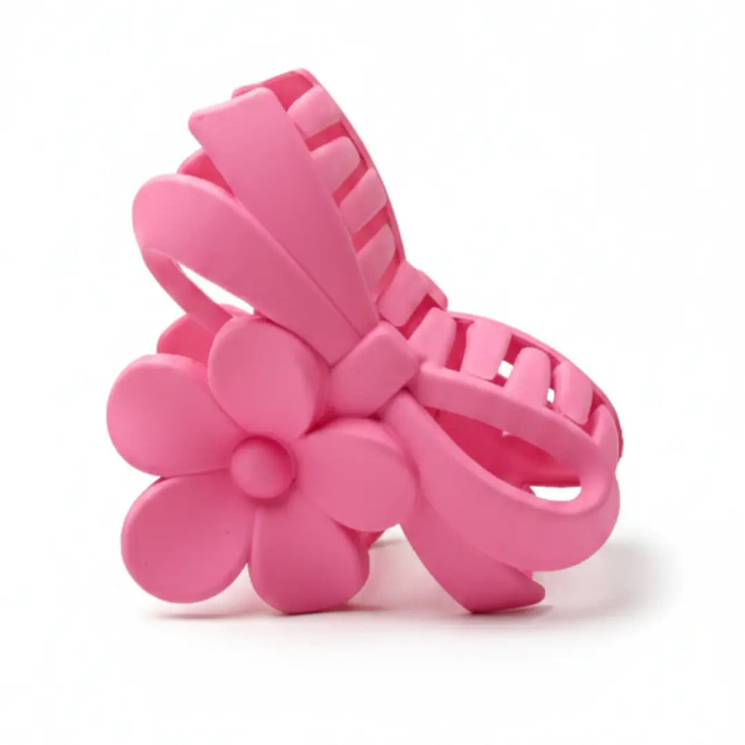 Product shot of pink matte hair claw showing flower and loop design