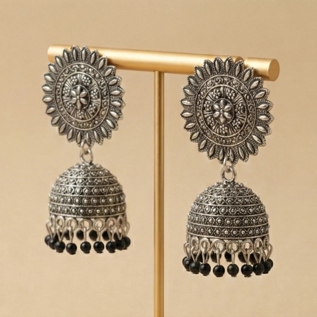 Side profile of traditional Pakistani silver jhumkas showing the dome shape and craftsmanship.
