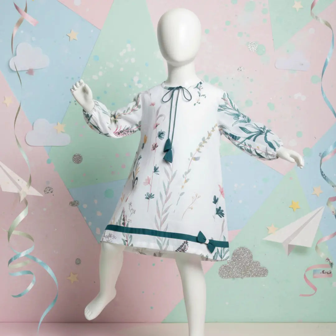 Full body view of mannequin wearing white floral print girls tunic with long balloon sleeves and teal accents
