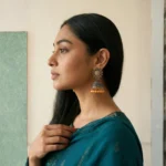Angled view of lightweight gold-plated jhumka earrings for girls, highlighting the traditional antique design and dangling pearl embellishments.