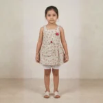 Full-length front view of Aaliya wearing a KIDS beige floral printed cotton frock with white frill bloomers by Applique Threads.